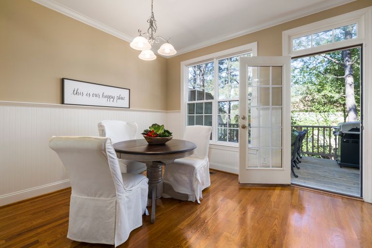 Elegant dining room with a view of a sunny patio, featuring modern decor and inviting ambiance.